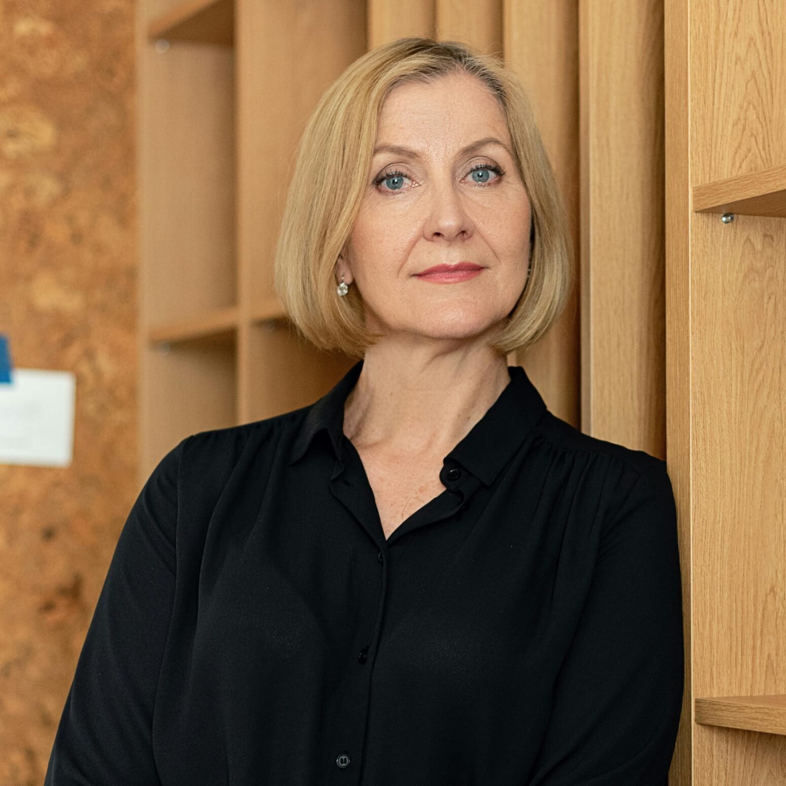 Confident businesswoman standing in an office setting, showcasing leadership.